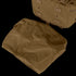 A folded brown tarp is placed next to a Condor Orion Assault Backpack 50L, a tan bushcraft or EDC pack with straps and loops, resting on a light surface.